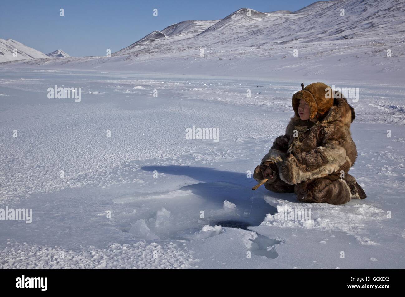 Rentier-Nomaden-junge gekleidet in Rentier Skins Eisfischen, Chukotka autonomes Okrug, Sibirien, Russland Stockfoto