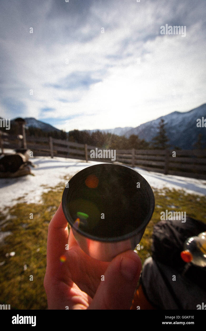 Wanderer hält eine Tasse, Koegl Alp (1432 m), Abstieg vom Unnutz Berg (2078 m), Rofan Gebirge, Tirol, Österreich Stockfoto