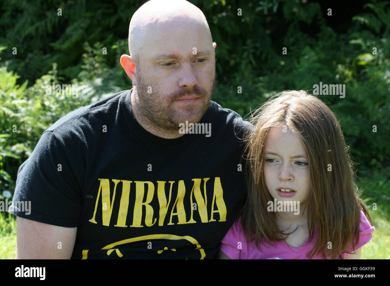 Vater mit Arm um Tochter Stockfoto