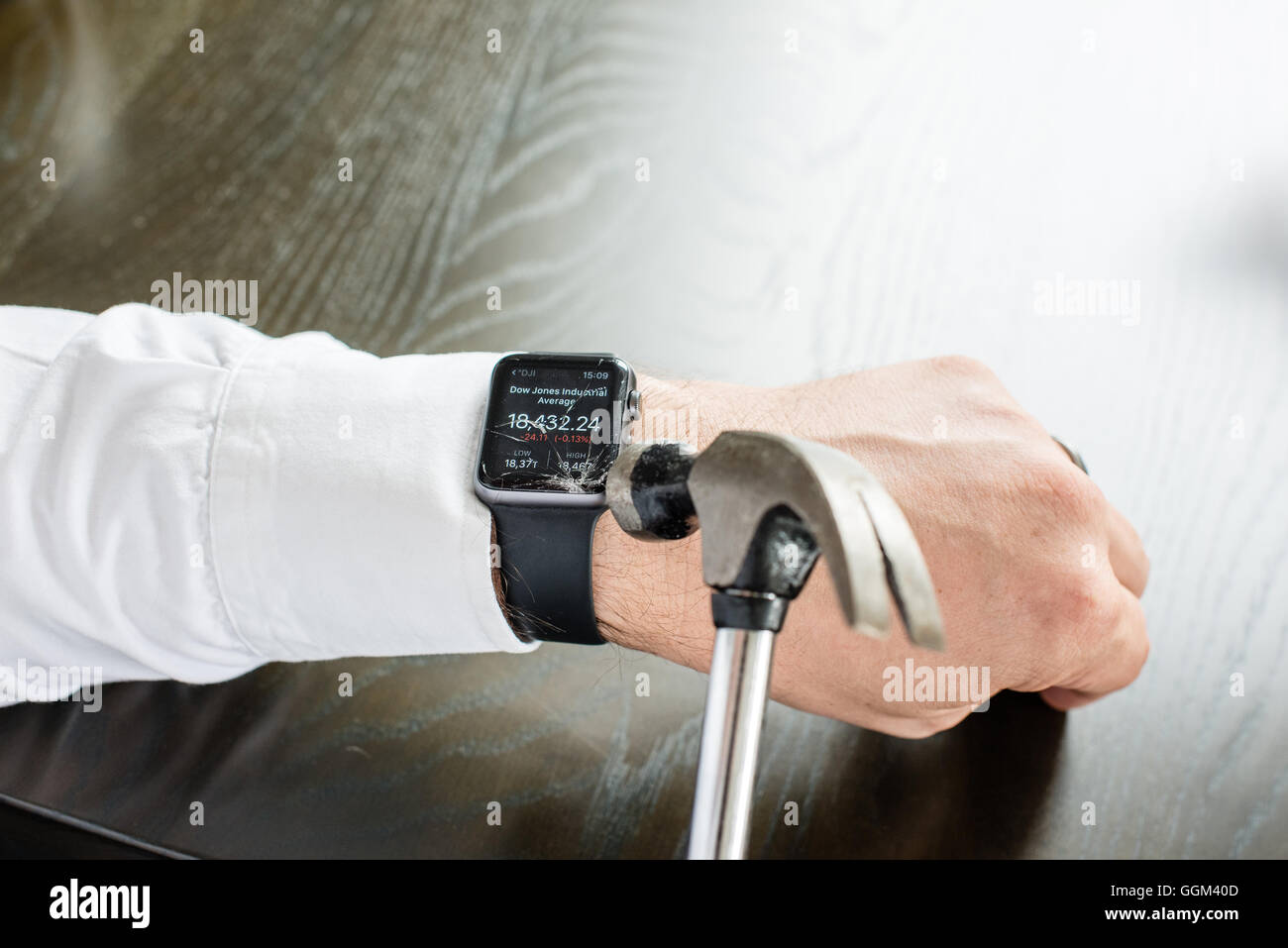 Ostfildern, Deutschland - 31. Juli 2016: Ein Geschäftsmann trägt ein weißes Hemd ist die Apple Watch am Handgelenk mit einem Hamm zu zerstören Stockfoto