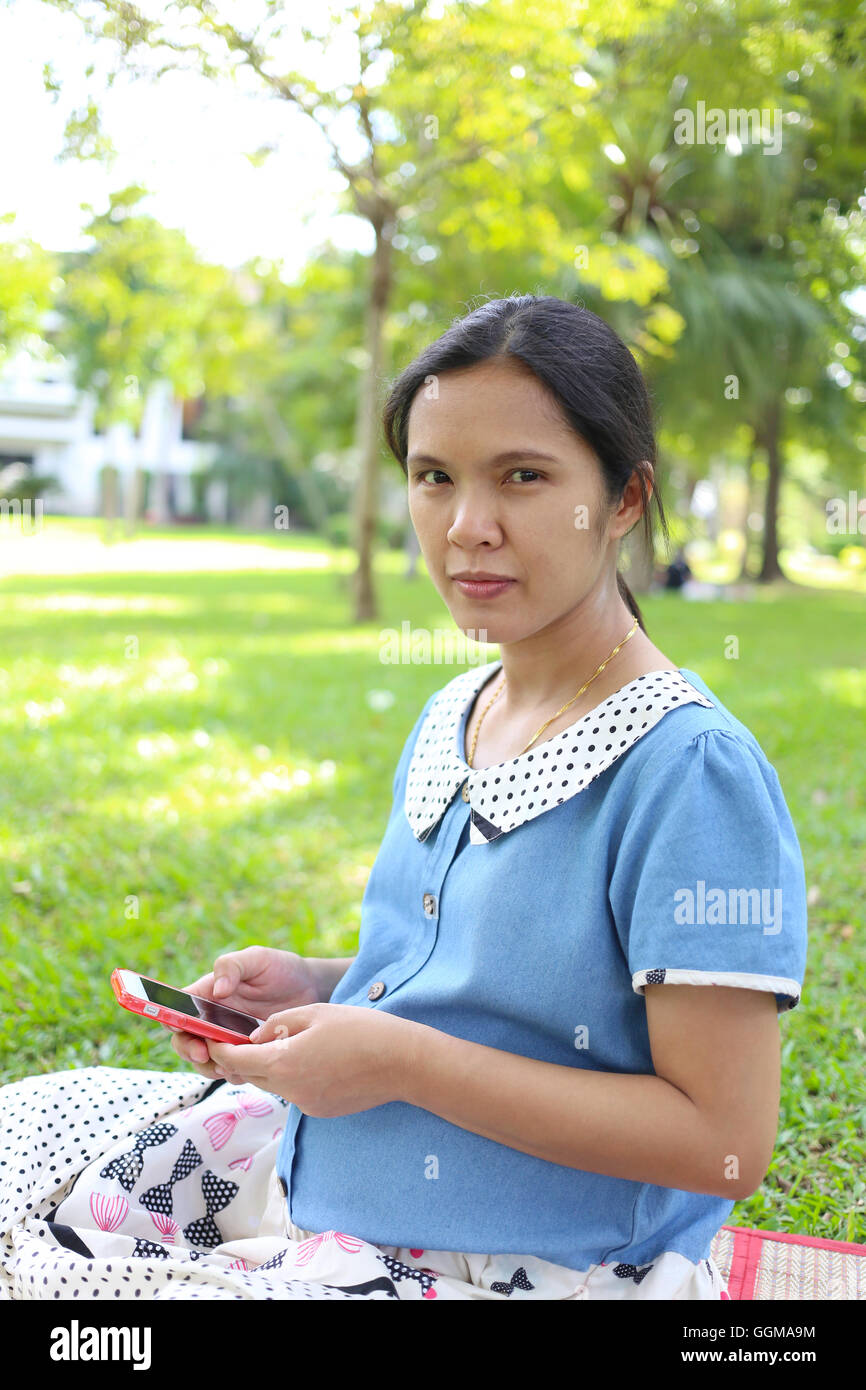 Schwangere Frauen mit Smartphones, um Informationen zur Gesundheitsversorgung im öffentlichen Park zu suchen. Stockfoto