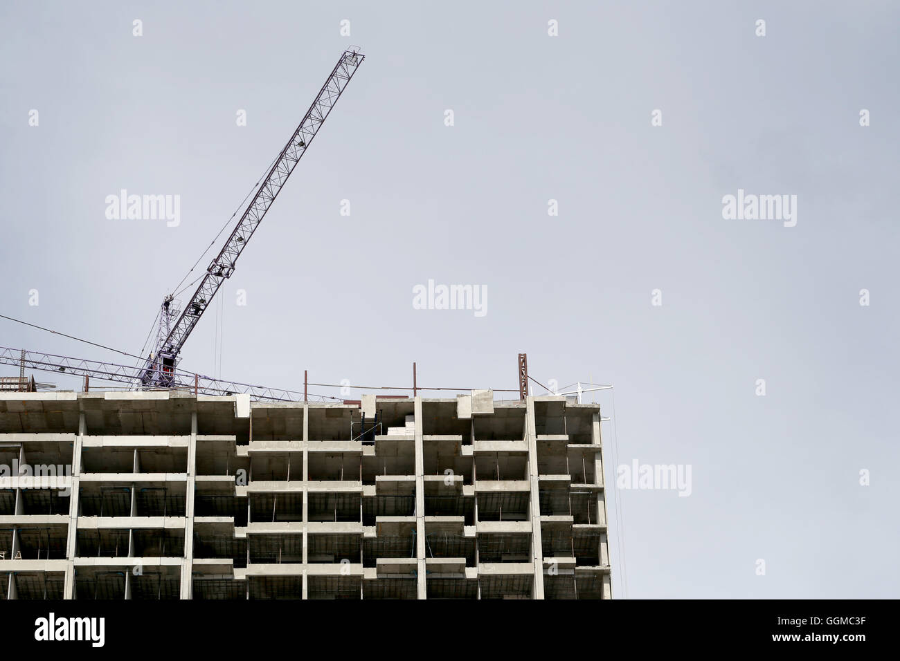 Kran arbeiten an einem Gebäude im Bau in grauen Hintergrund. Stockfoto