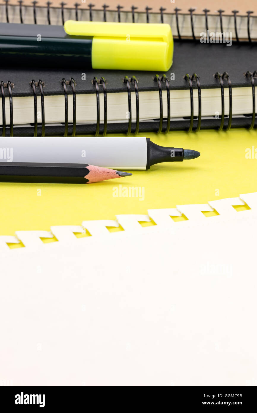 leere Seite von Notebook und Marker auf gelben Tabellenhintergrund Stockfoto