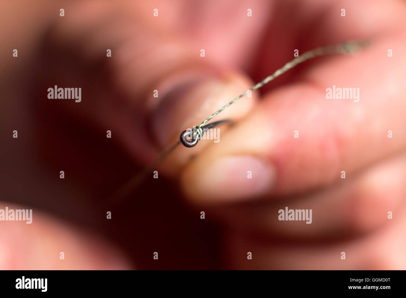 Hand des Mannes ein Angelhaken binden. Binden Sie das Rig. Selektiven  Fokus. Krawatte Haken hautnah. Binden Sie Fischen Haken binden einen  Angelhaken Prozess Stockfotografie - Alamy