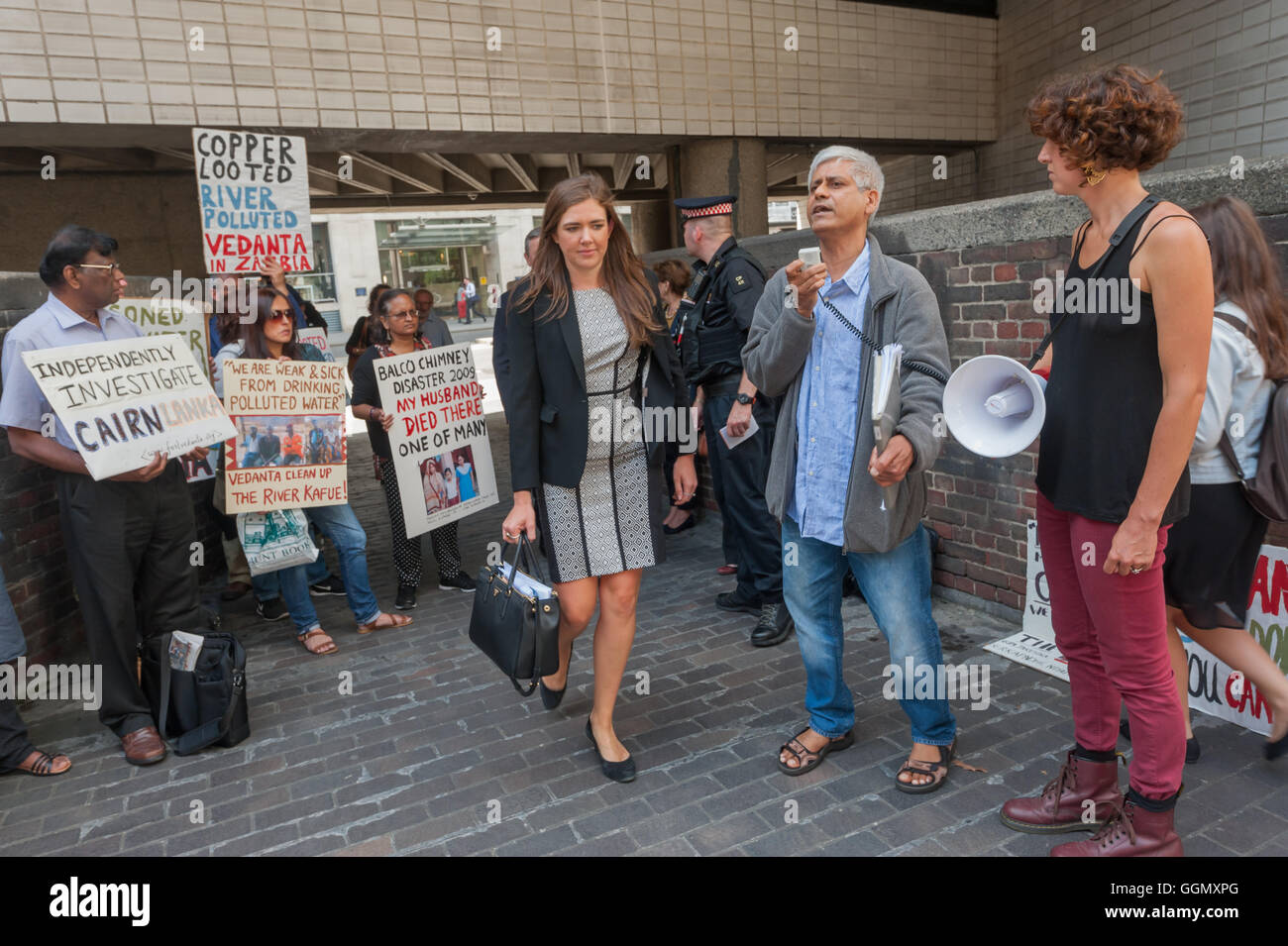 London, UK. 5. August 2016. Besucher der Vedanta AGM vorbeigehen Demonstranten repräsentieren Gemeinschaften auf der ganzen Welt, deren Leben beschädigt wurden, durch den Bergbau Riese, 69 % im Besitz von Milliardär Vorsitzender Anil Agarwal und seine Familie mit einem lauten Protest außerhalb und einige halten Anteile an der Besprechung teilnehmen. Das Unternehmen wurde für schuldig befunden der Wasserverschmutzung in Sambia Vergiftungen bis zu 40.000 Menschen im Jahr 2006, und weite Besteuerung Betrug aufgedeckt wurden. Bildnachweis: Peter Marshall/Alamy Live-Nachrichten Stockfoto