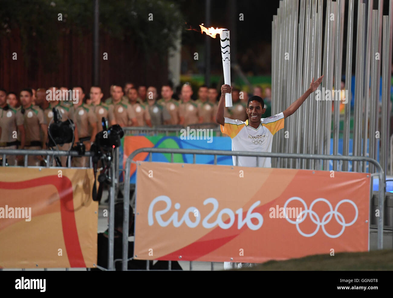 Rio De Janeiro, Brasilien. 6. August 2016. Brasilianische Jorge Alberto Oliveira Gomes hält die Olympische Fackel an der Praça Pio X schließen die Candelaria Curch (Igreja de Nossa Senhora da Candelária) in Rio City nach der Eröffnungszeremonie der Rio 2016 Olympischen Spiele in Rio De Janeiro, Brasilien, 6. August 2016. Foto: Sebastian Kahnert/Dpa/Alamy Live News Stockfoto