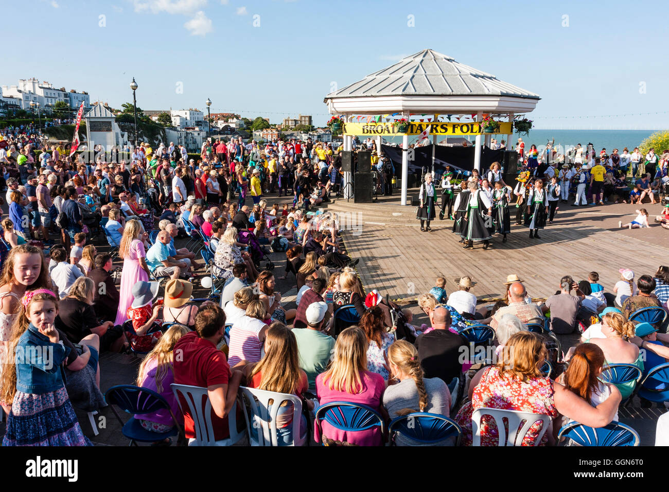 Broadstairs Folk Week-Festival. Parade. Offcumduns Morris Gruppe tanzen vor Band stehen. Heller Sonnenschein, Sommer. Stockfoto