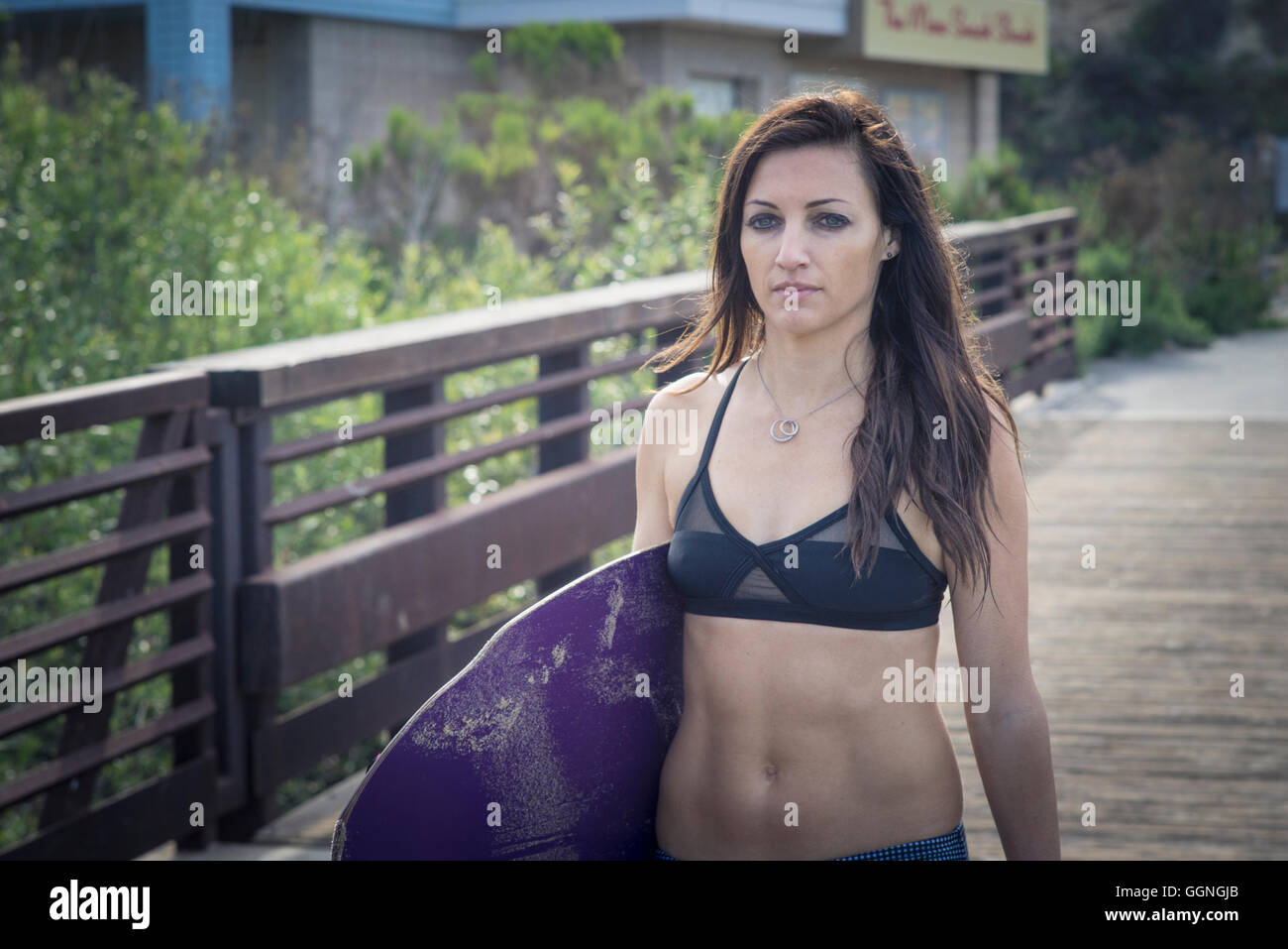 Kaukasische Frau Skimboard auf Promenade Stockfoto