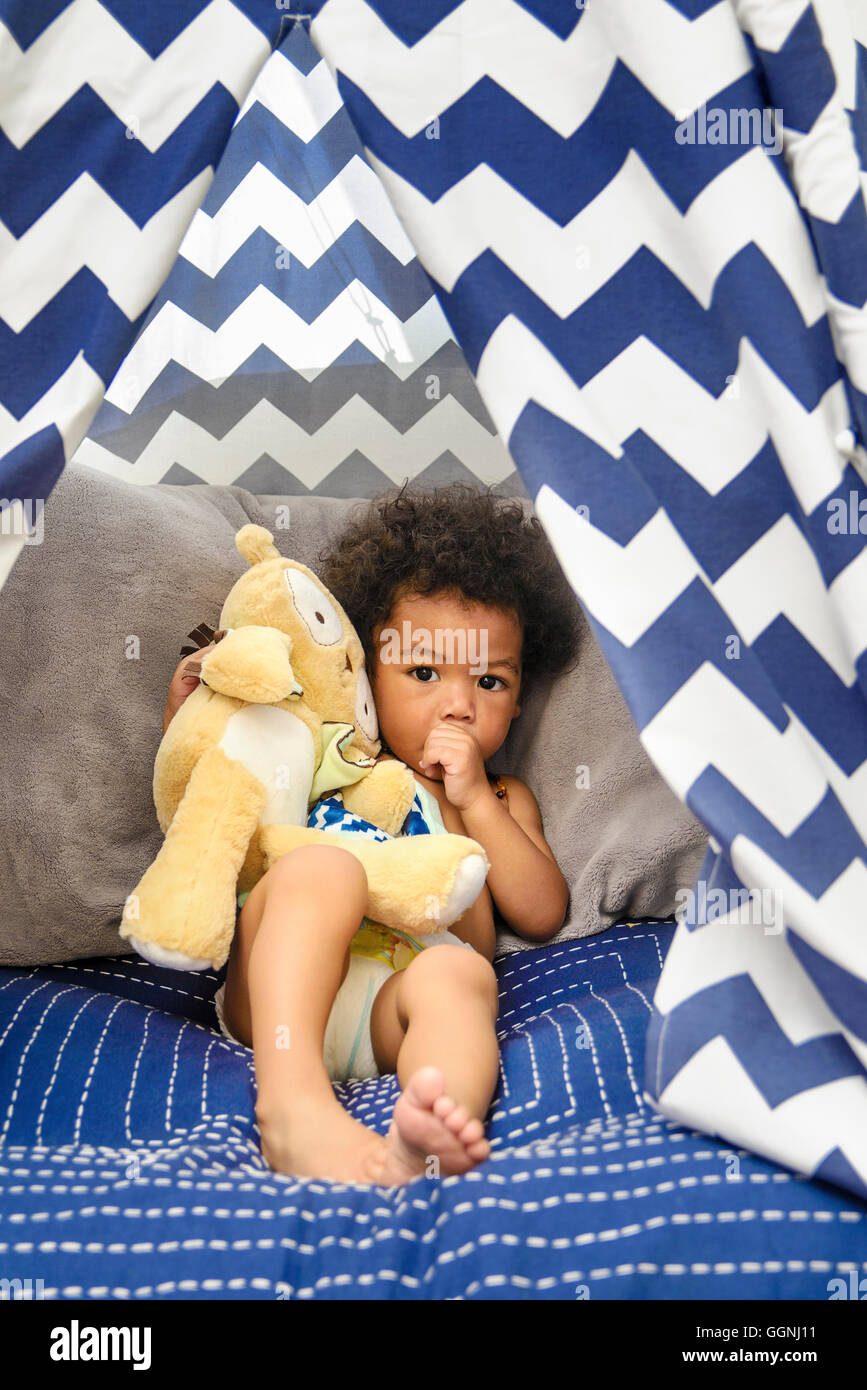 Gemischte Rennen Baby jungen Saugen Daumen halten Stofftier Stockfoto