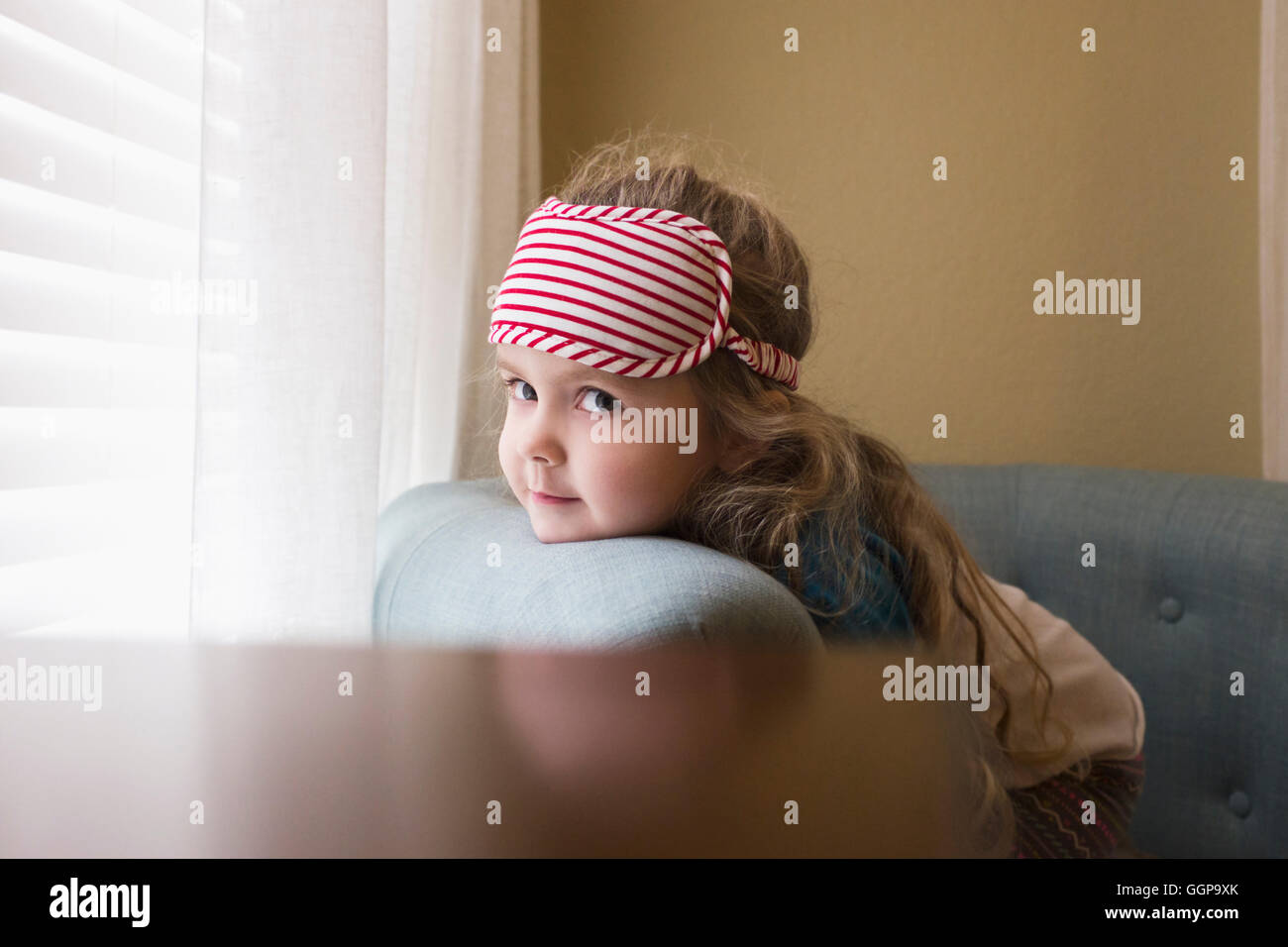 Kaukasische Mädchen ruhen Kinn auf Sofa in der Nähe von Fenster Stockfoto