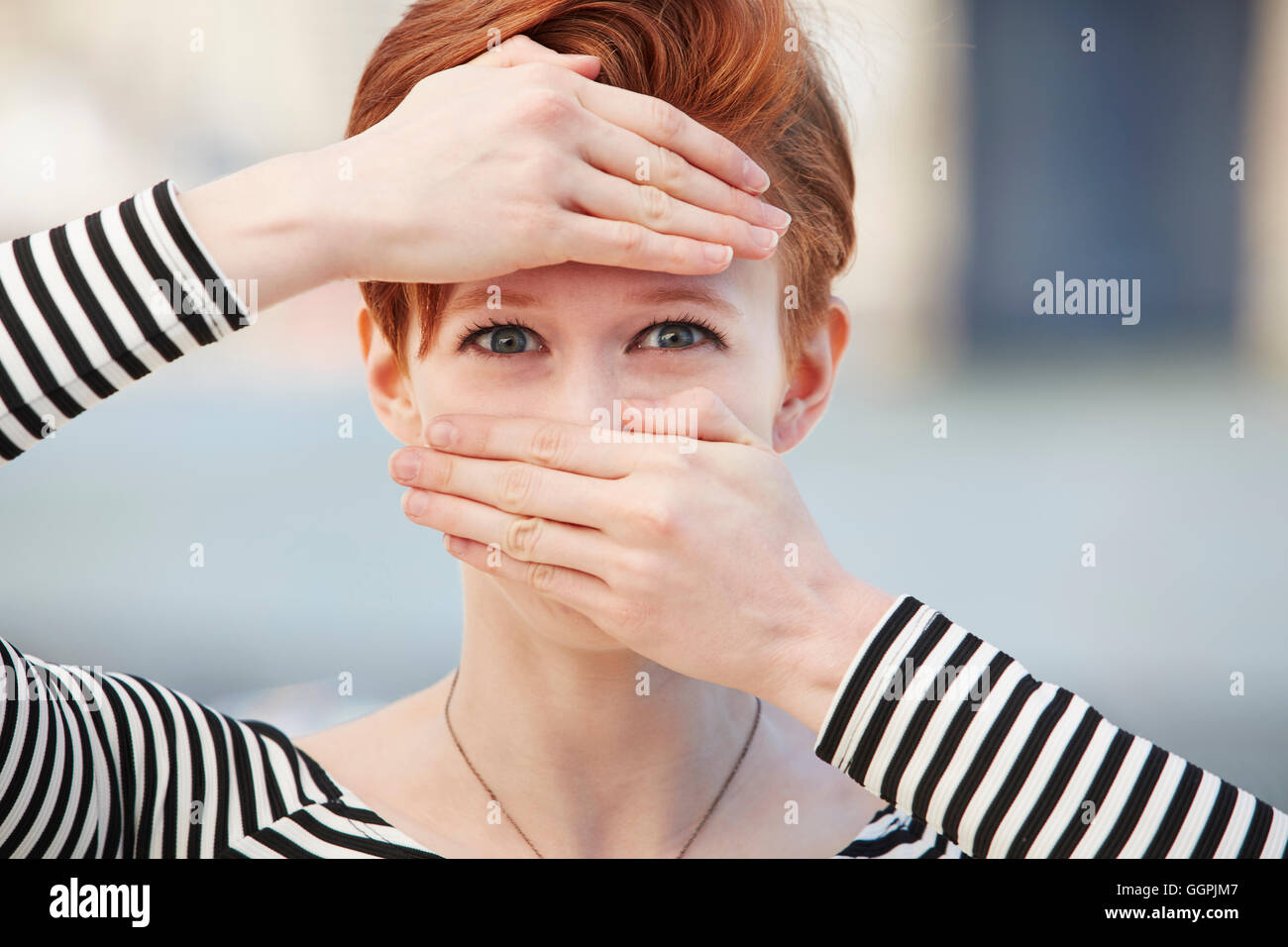 Kaukasische Frau für Mund und Stirn mit Händen Stockfoto