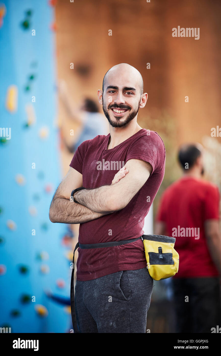 Lächelnd Hispanic Mann mit verschränkten bei outdoor-Kletterwand Stockfoto