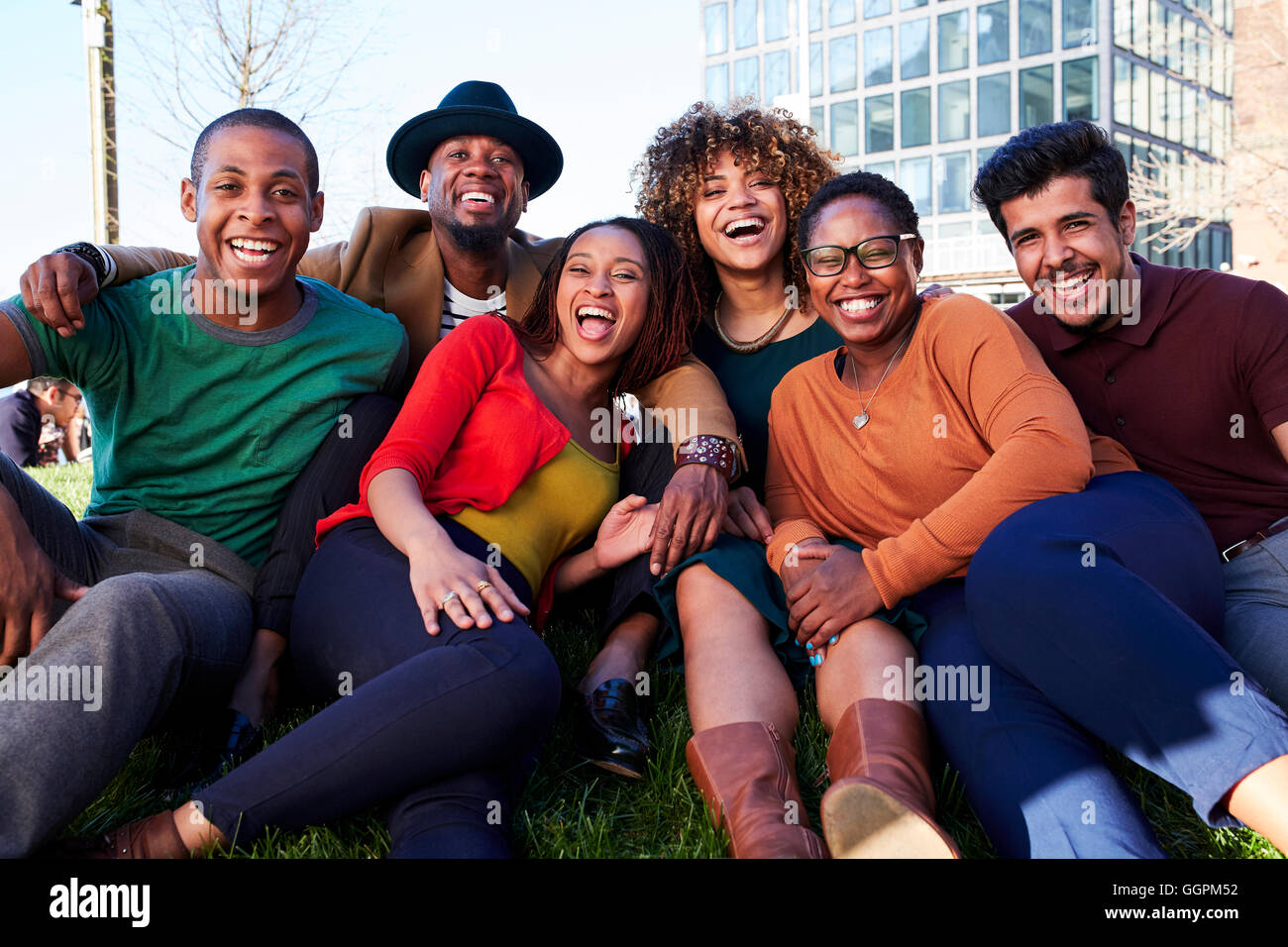 Freunde im Rasen sitzen und lachen Stockfoto