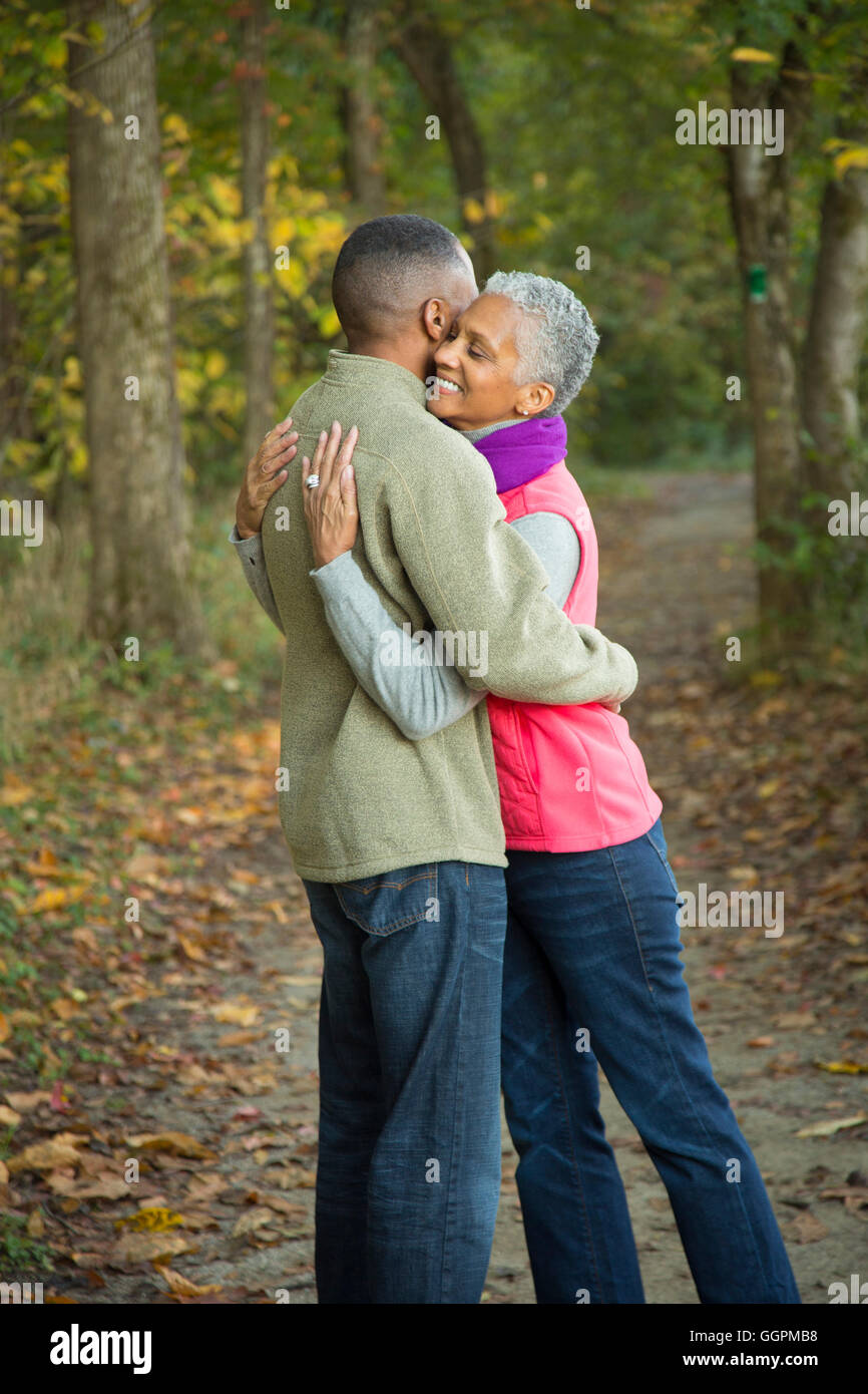 Älteres Ehepaar umarmt im Wald Stockfoto