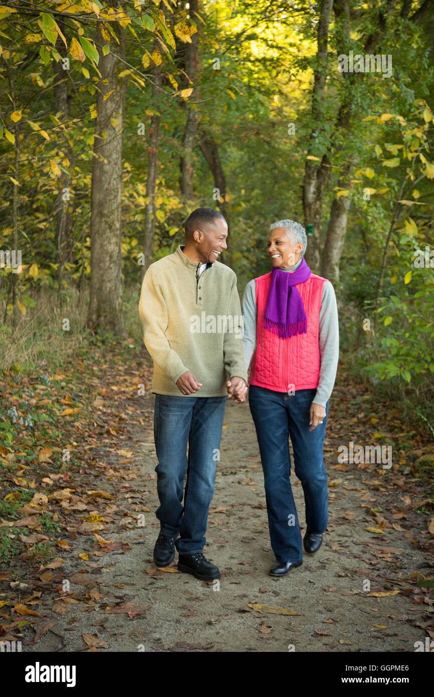 Älteres Paar Hand in Hand spazieren im Wald Stockfoto