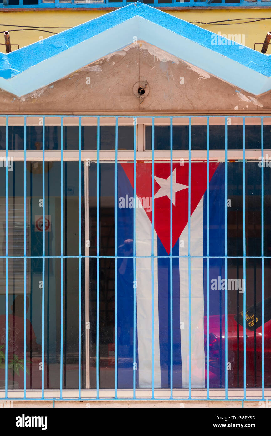 Eine kubanische Flagge hängt in einem Fenster hinter Gittern in Regla, Havanna, Kuba. Stockfoto