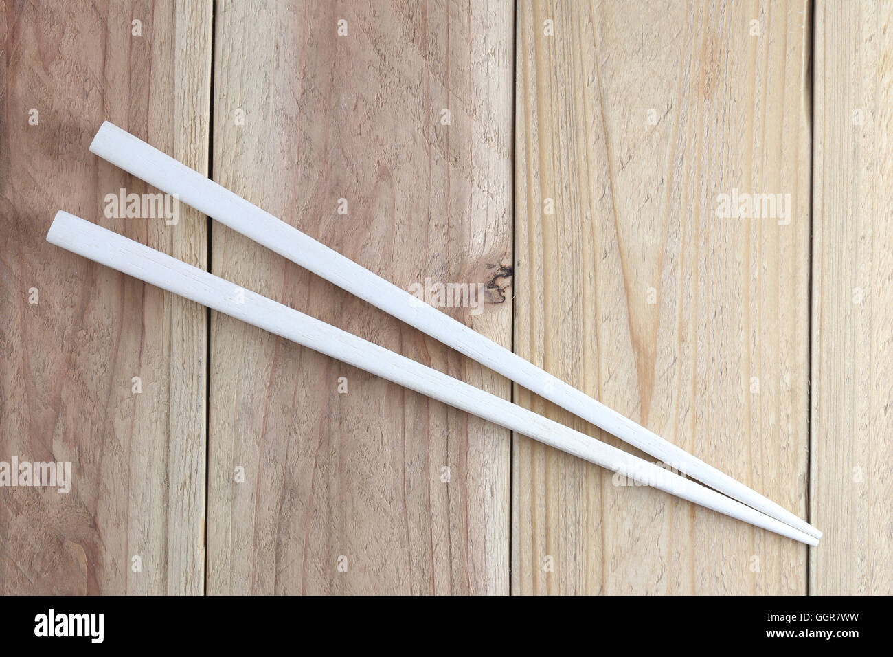 weiße Stäbchen Löffel auf Holzboden für die Design-Essen-Konzept-Hintergrund. Stockfoto