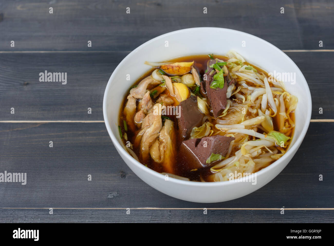 Nudelsuppe in Schüssel auf einem Holztisch, thailändische Spezialitäten Stockfoto