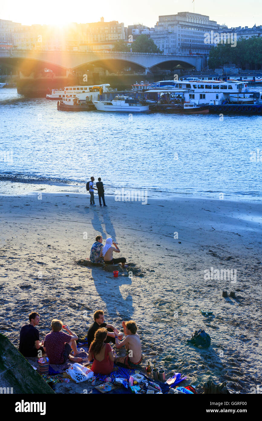 London, Waterloo. Einheimische an einem Themse-Strand im Sommer mit Waterloo Bridge im Hintergrund Stockfoto