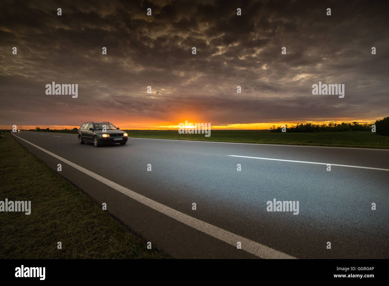 Auto fahren auf Autobahn bei Sonnenuntergang Stockfoto