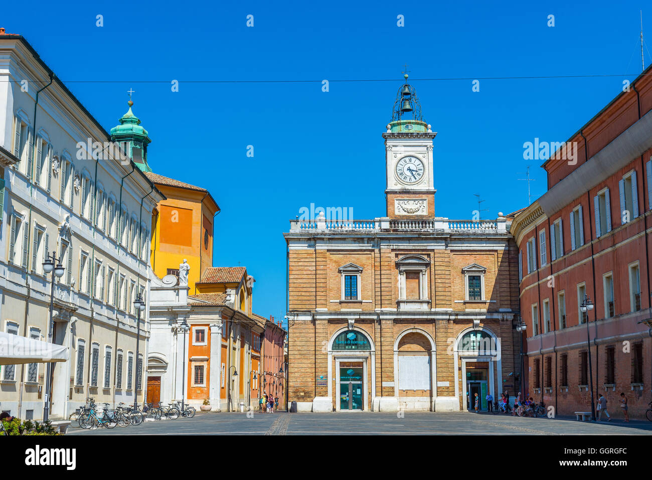 Radfahrer kreuzen Piazza Del Popolo Quadrat von Ravenna mit Orologio Turm und Palazzo del Governo Schloss im Hintergrund. Italien. Stockfoto