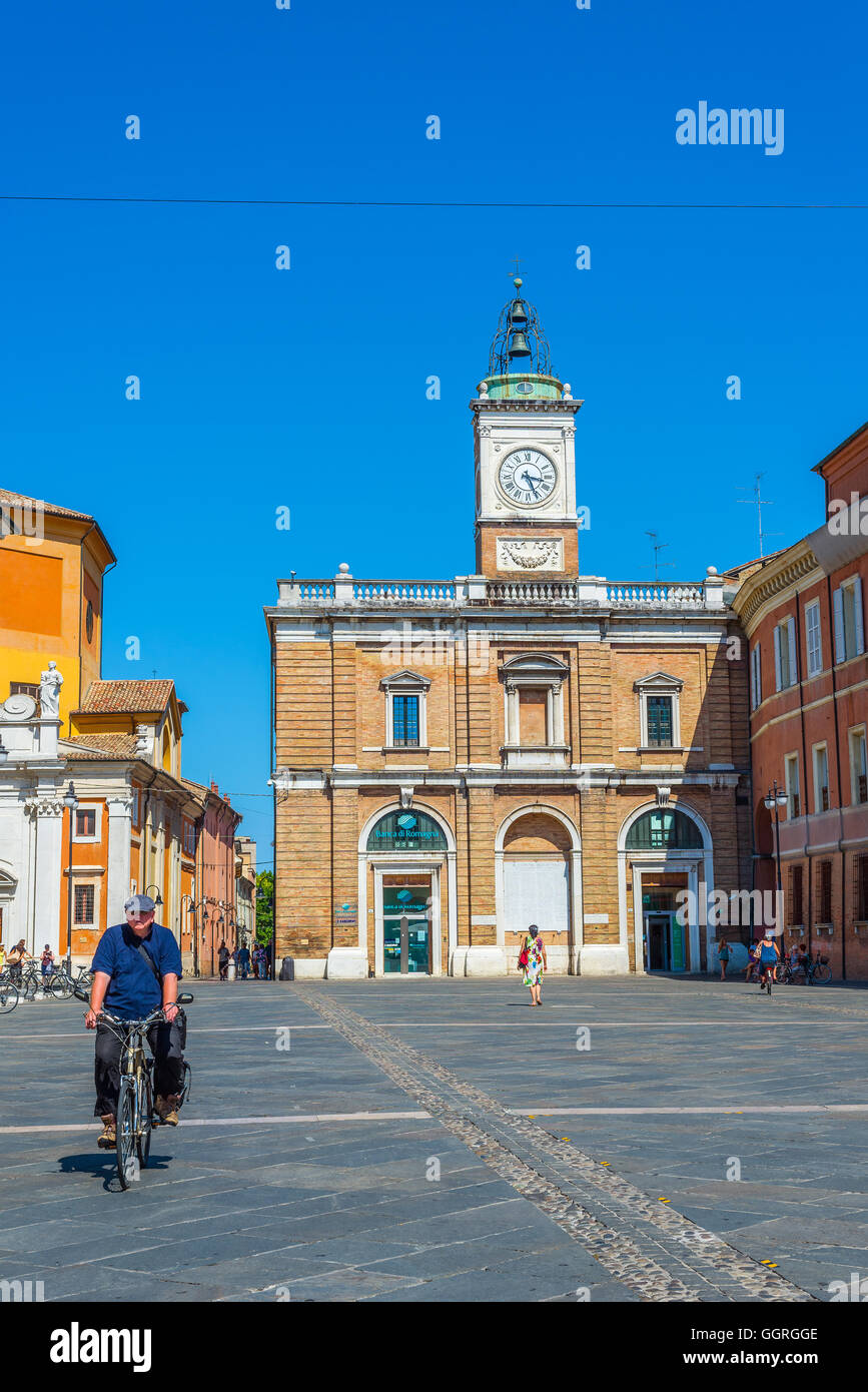 Radfahrer kreuzen Piazza Del Popolo Quadrat von Ravenna mit Orologio Turm und Palazzo del Governo Schloss im Hintergrund. Italien. Stockfoto