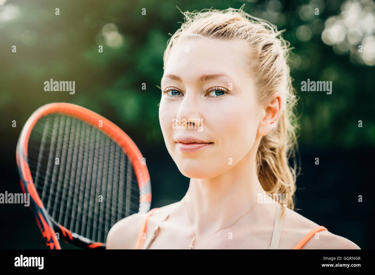 Lächelnde Frau kaukasischen holding Tennisschläger Stockfoto
