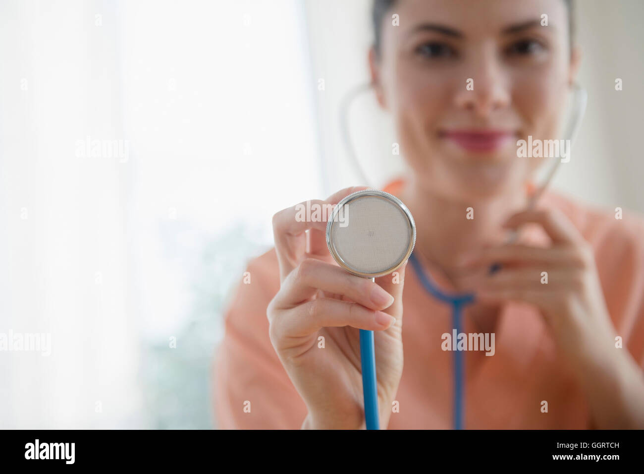 Kaukasischen Krankenschwester mit Stethoskop hören Stockfoto