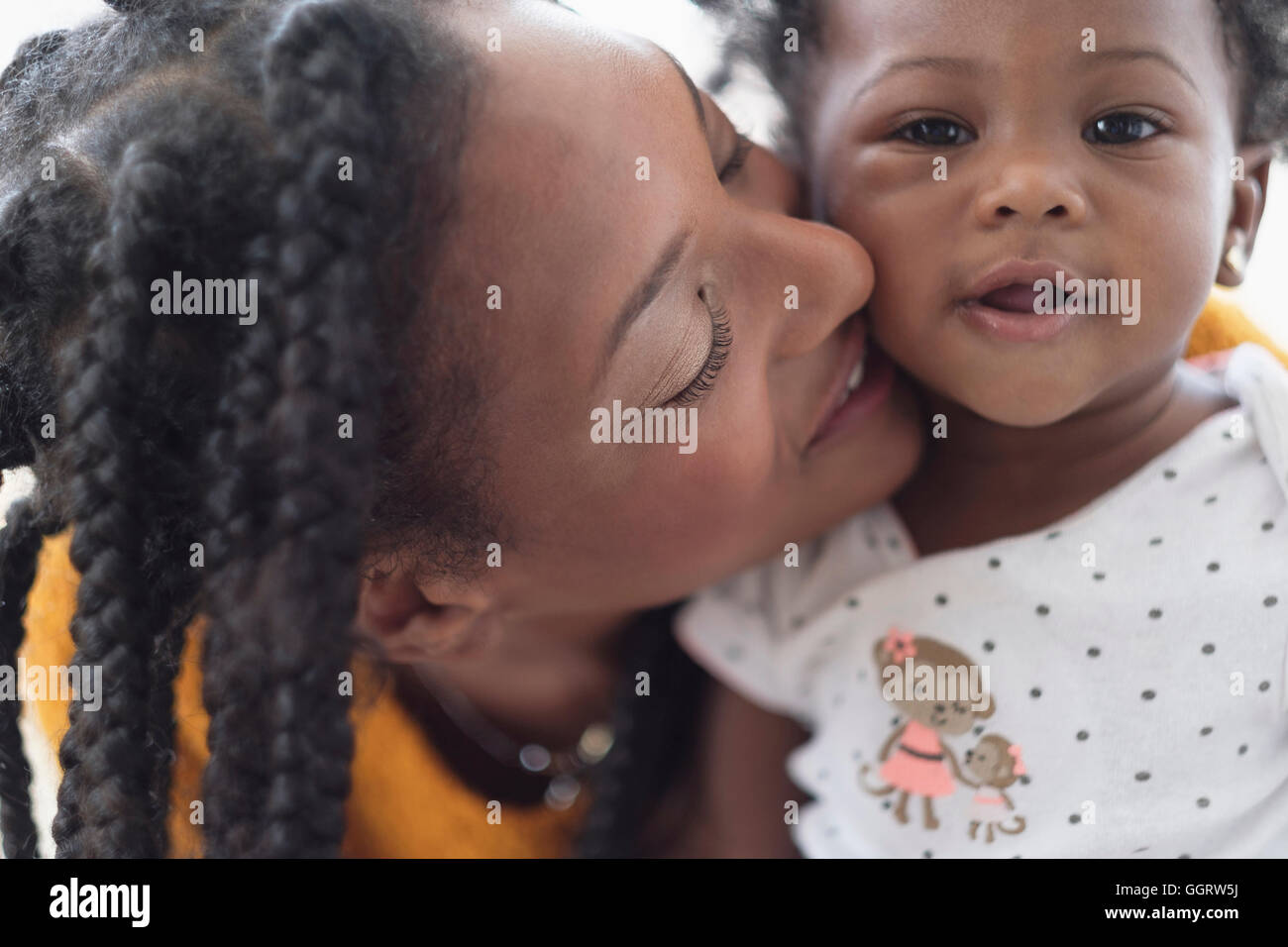 Lächelnde schwarze Frau Wange an Wange mit Tochter Stockfoto
