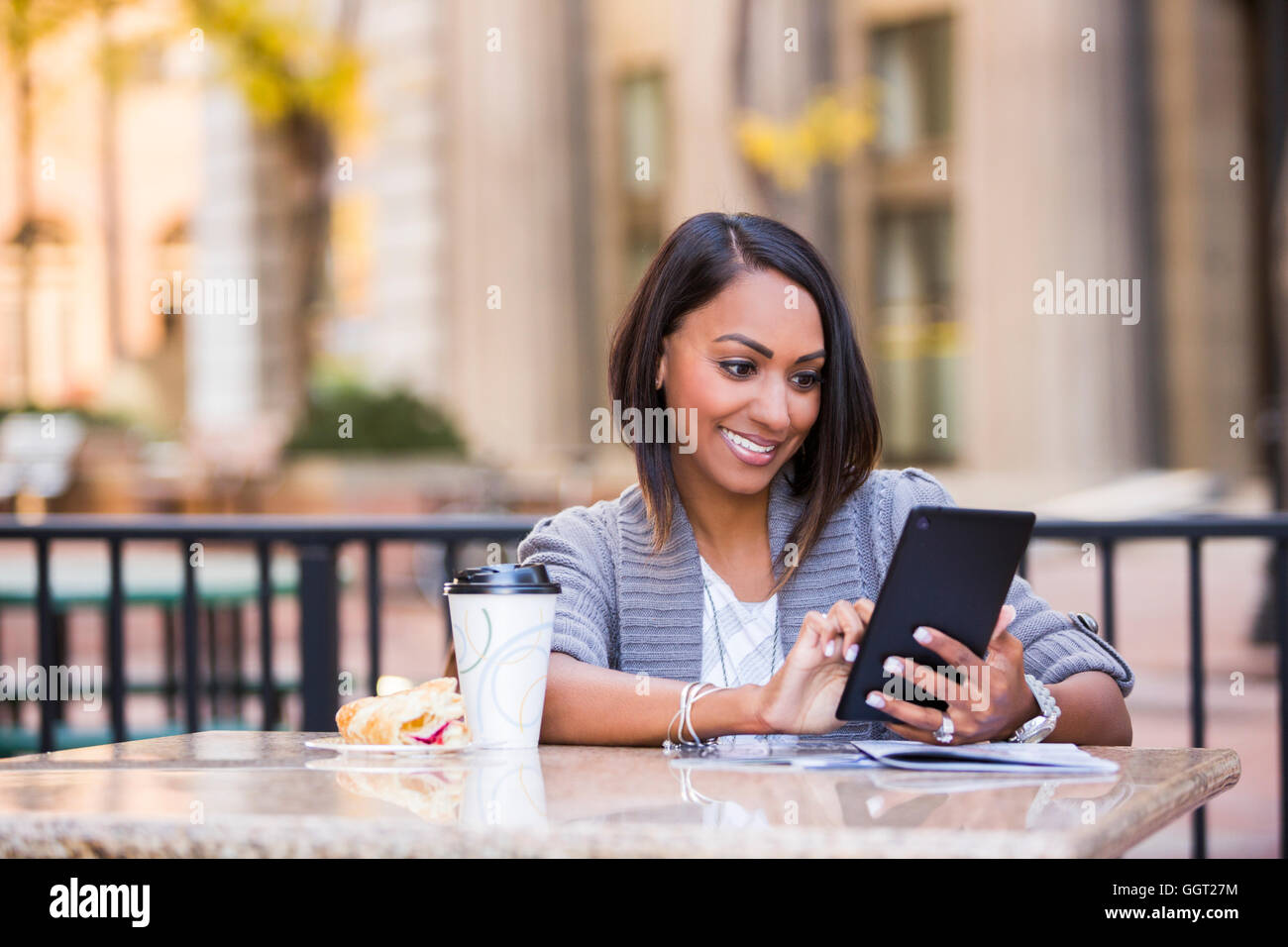 Indische Frau liest digital-Tablette auf Terrasse Stockfoto