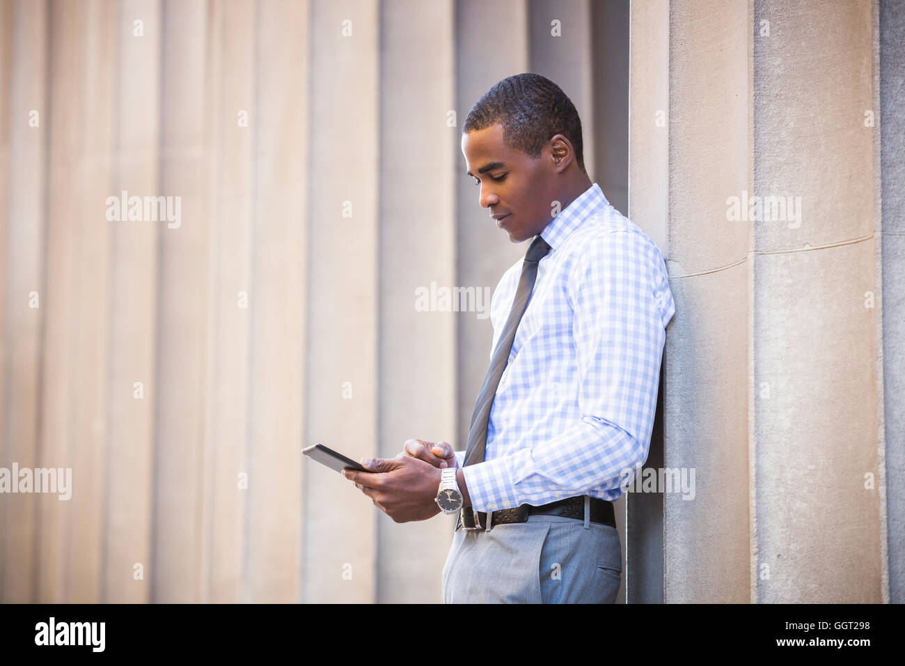 Schwarze Geschäftsmann stützte sich auf Wand mit digital-Tablette Stockfoto