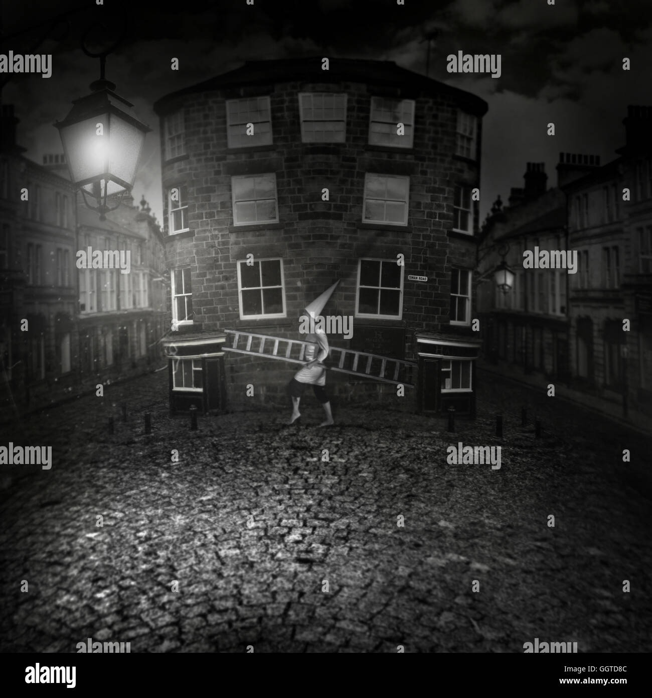 surreales Bild Figur Kegel Hut hält eine große Leiter auf gepflasterten Weg in der Altstadt zu Fuß in der Nacht Stockfoto
