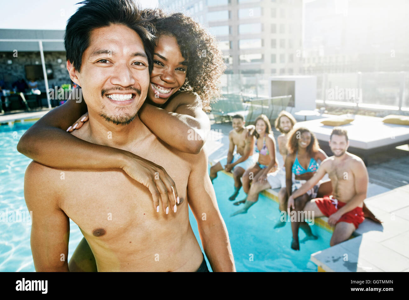 Lächelnden Freunde genießen städtische Schwimmbad Stockfoto