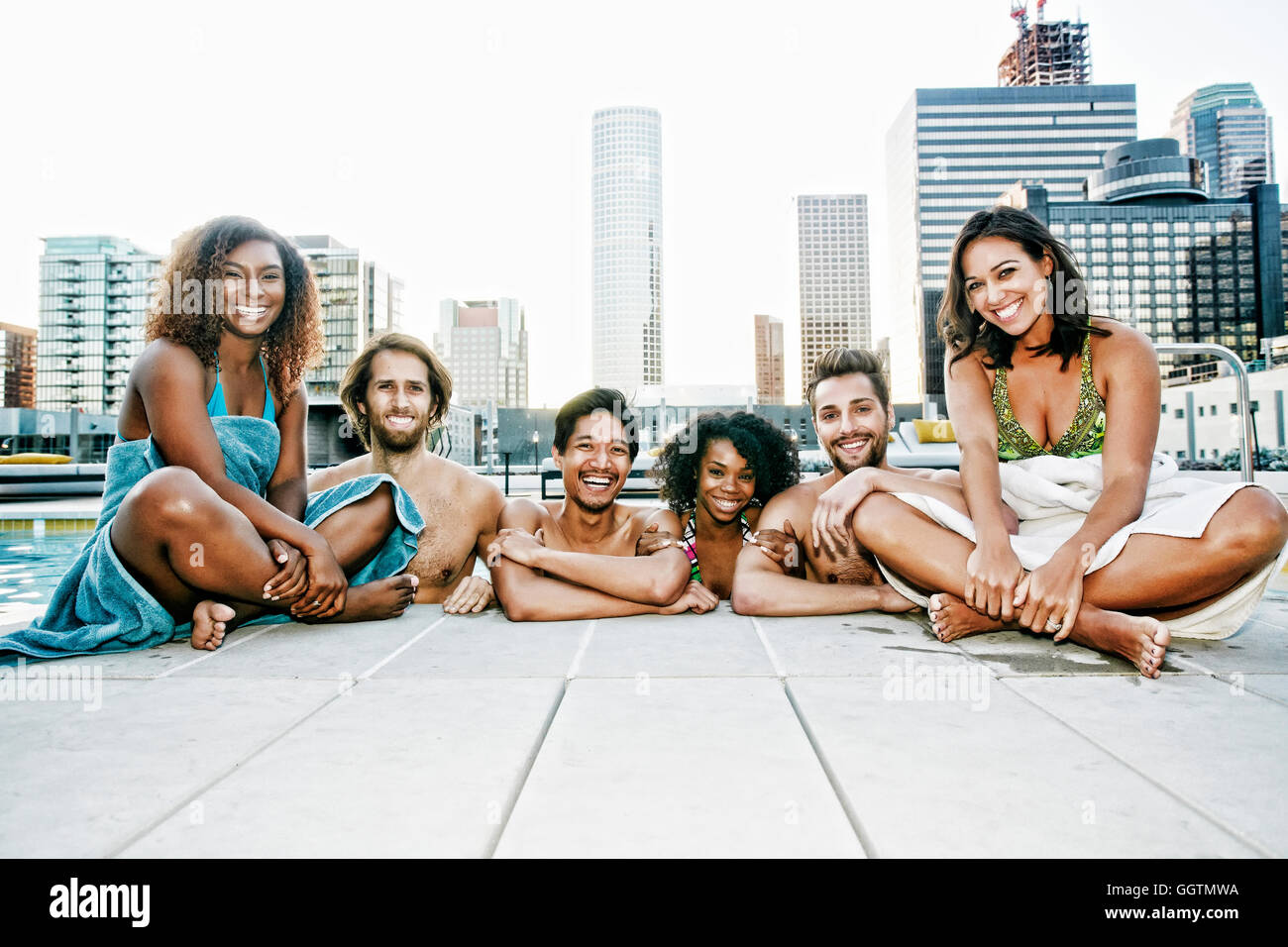 Lächelnden Freunde, entspannen am Pool im städtischen Schwimmbad Stockfoto