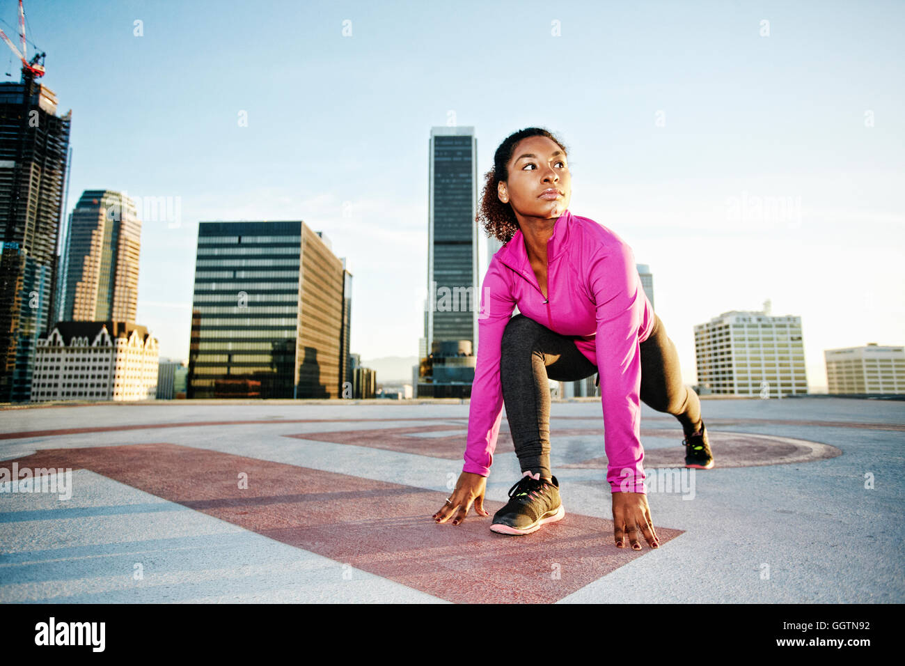 Schwarze Frau, die Dehnung der Beine auf städtischen Dach Stockfoto
