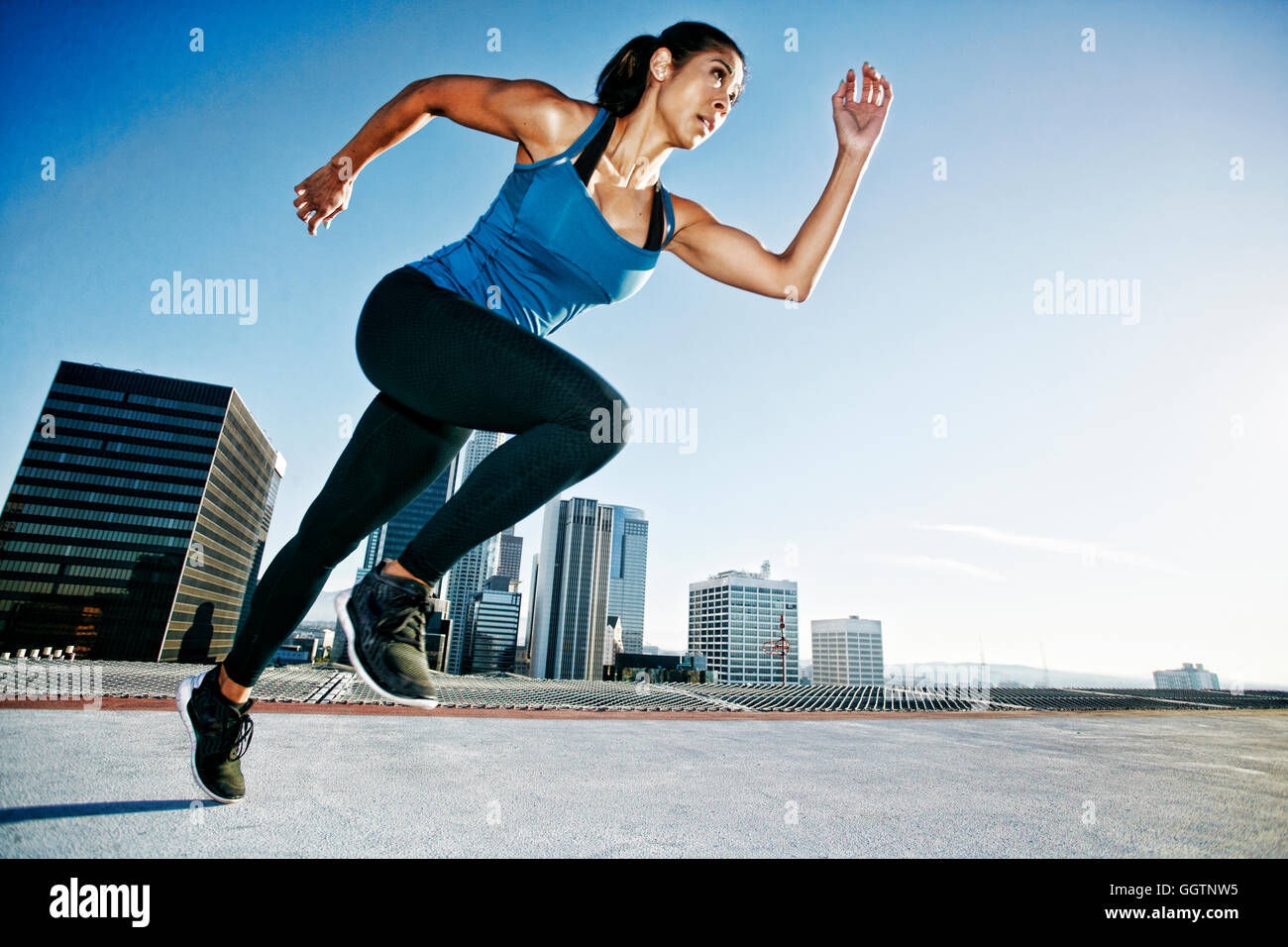 Gemischte Rennen-Frau läuft auf städtischen Dach Stockfoto