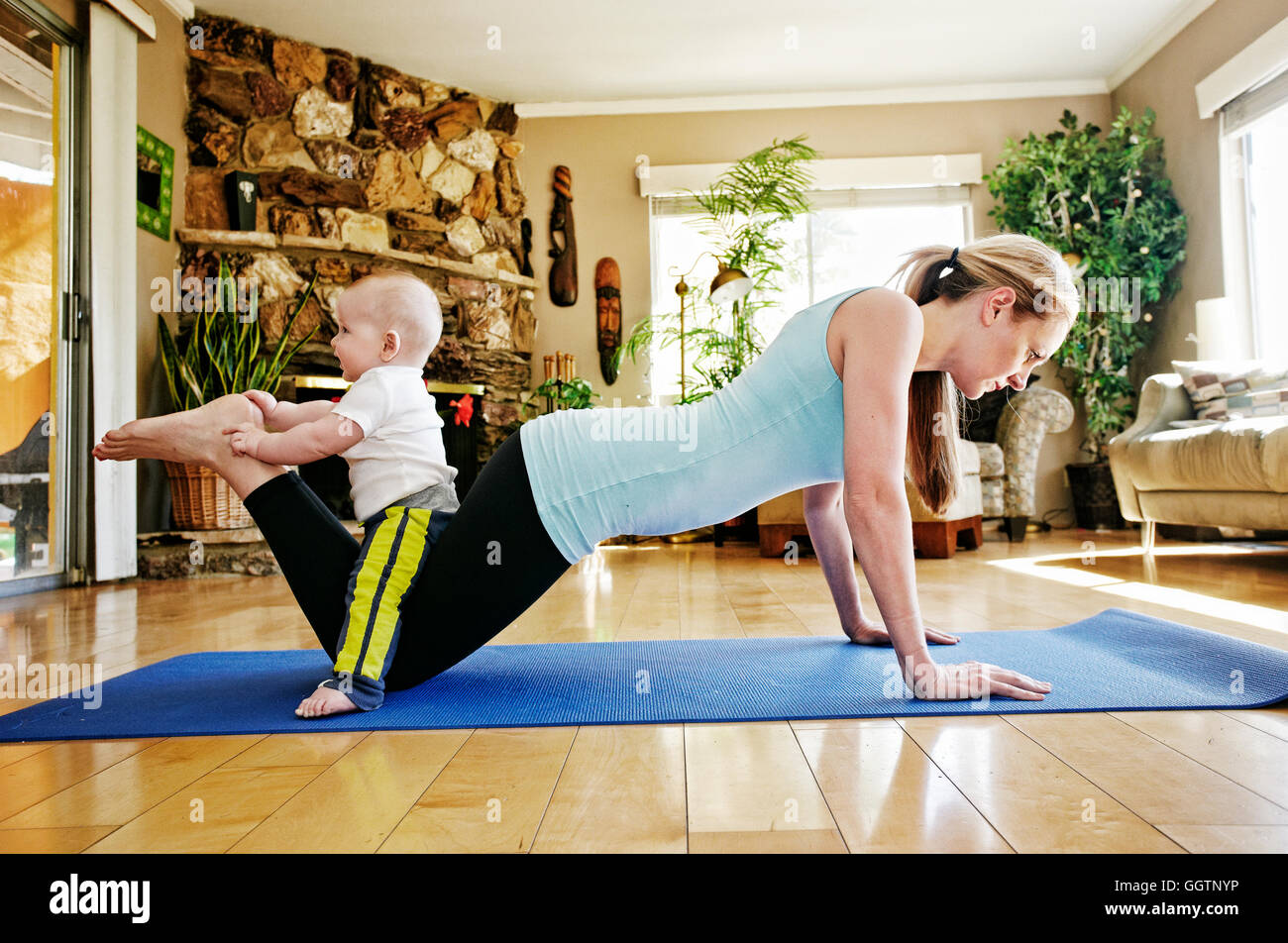 Mutter, arbeiten auf Gymnastikmatte mit Baby auf Beinen Stockfoto