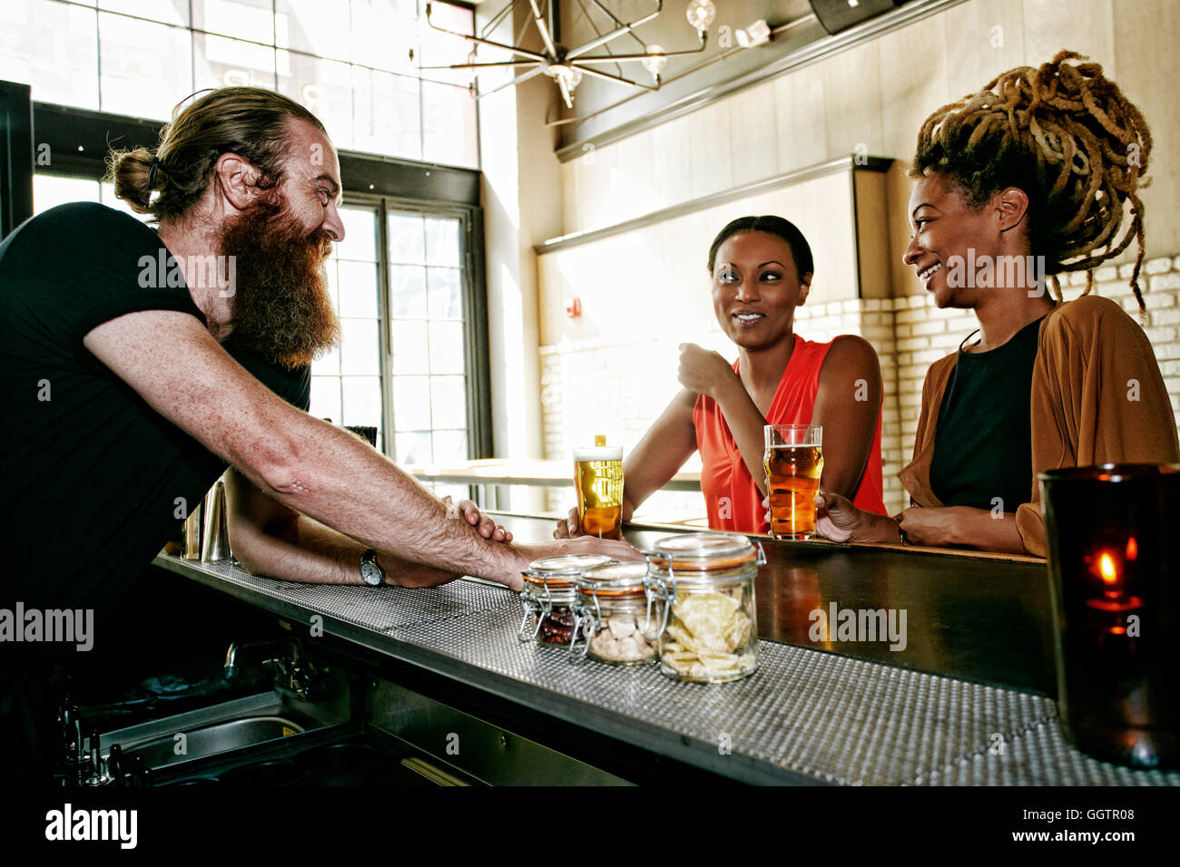 Barkeeper im Gespräch mit Kunden Stockfoto
