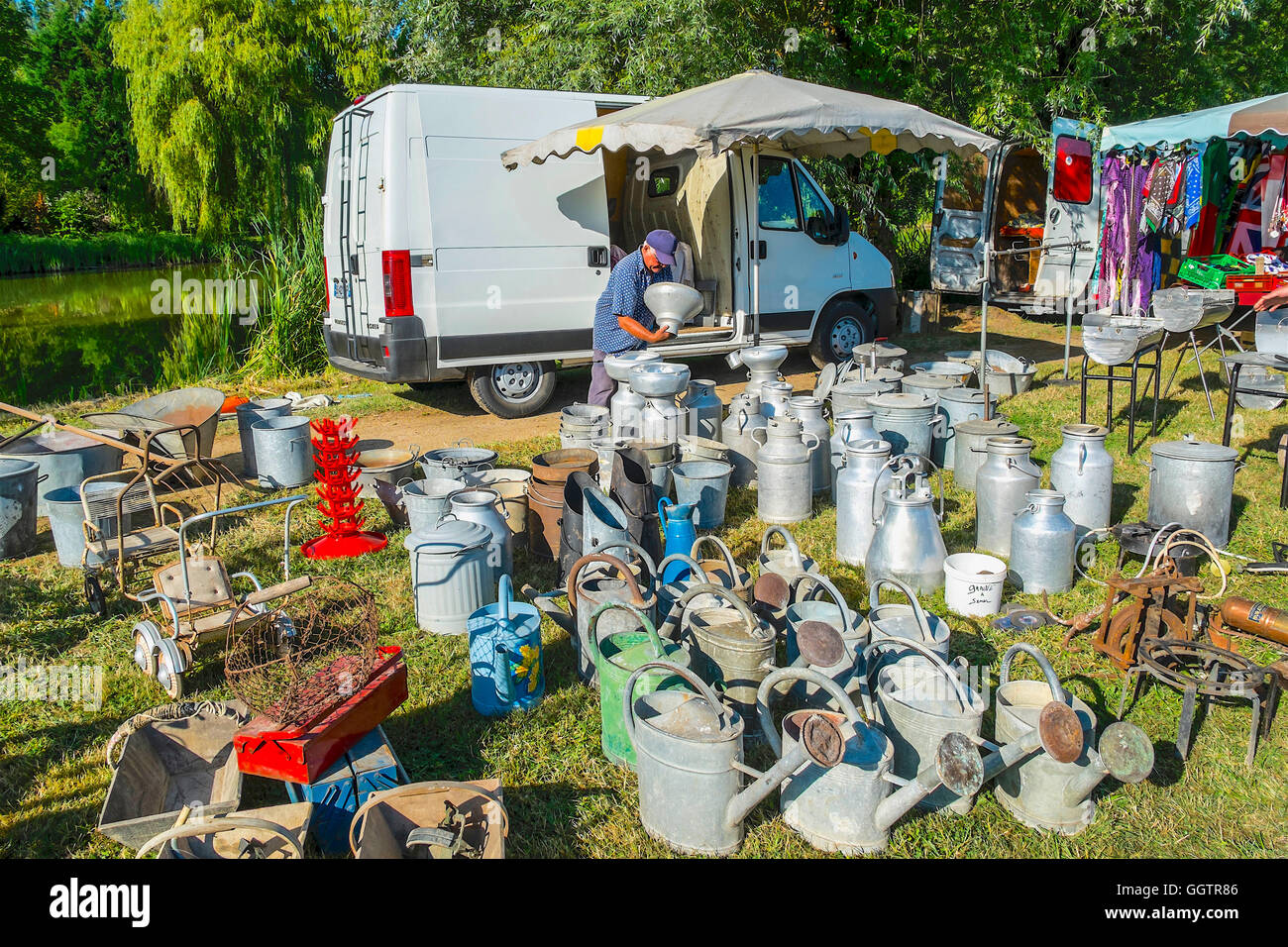 Stall-Inhaber verkaufen alte Gießkannen und Milchkannen bei Open-Air-Veranstaltung - Sud-Touraine, Frankreich. Stockfoto