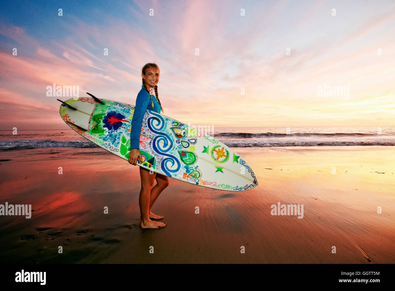 Kaukasische Frau mit Surfbrett am Strand Stockfoto