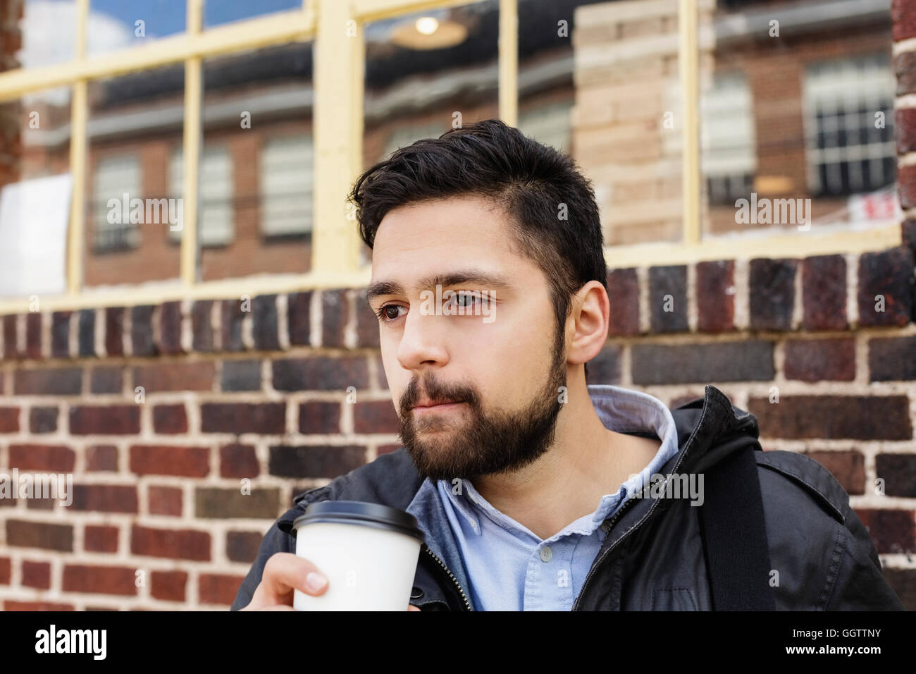 Hispanic Mann Tragetasche Kaffeetrinken in Stadt Stockfoto