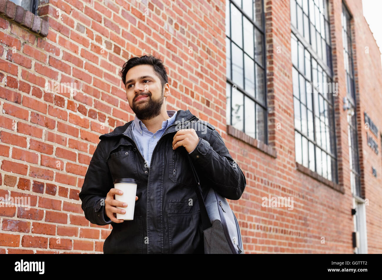Hispanic Mann Tragetasche und Kaffeetasse in Stadt Stockfoto