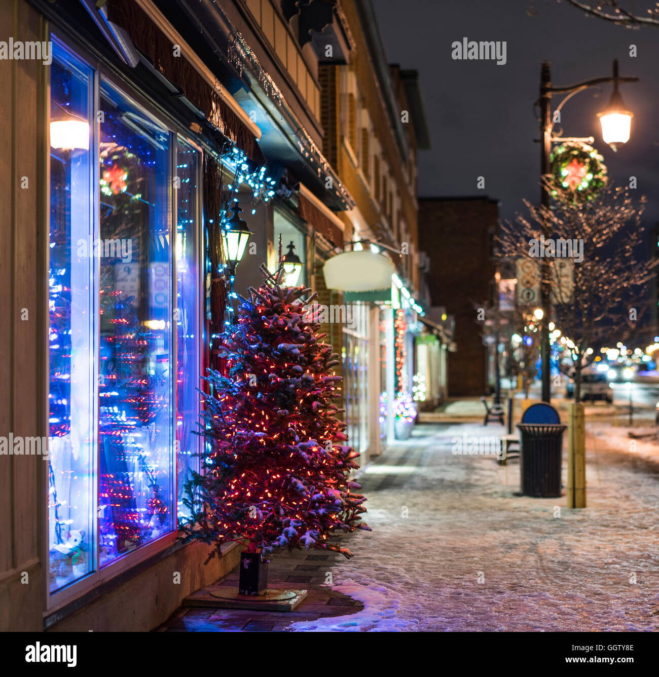 Schnee und Weihnachtsbaum auf Stadt Bürgersteig in der Nacht Stockfoto