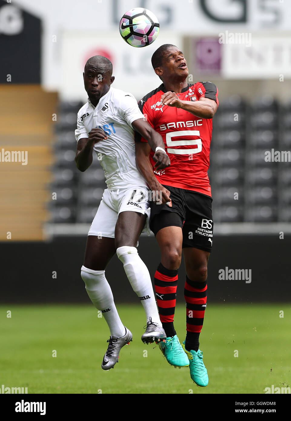 Swansea City Modou Barrow kämpft um den Ball mit Stade Rennaiss Ludovic Baal, während der Vorsaison Freundschaftsspiel im Liberty Stadium Swansea. Stockfoto