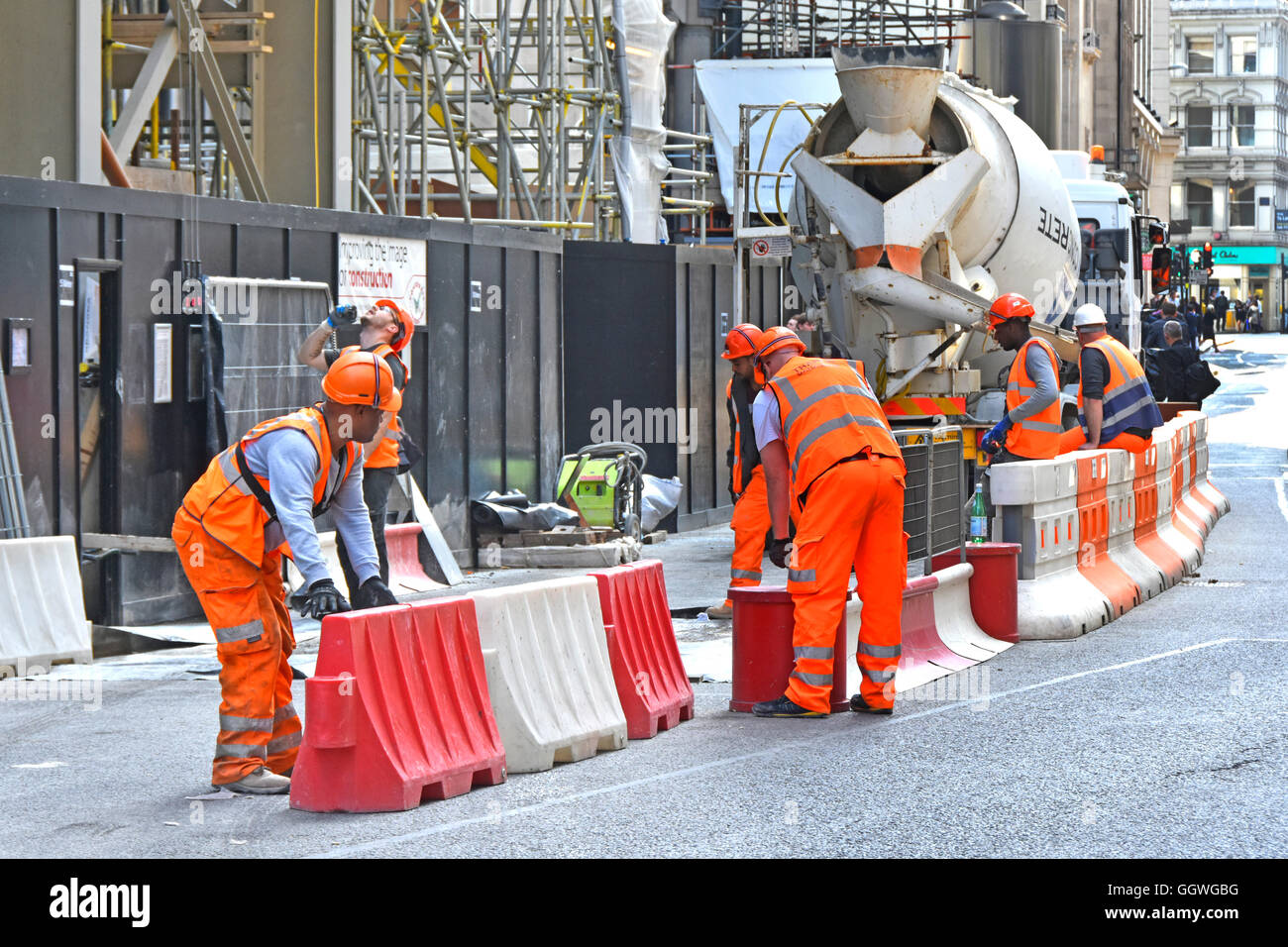 Helmarbeiter Baustelle London Anpassung der Straßenbarrieren für Zementmischer Fertigbeton Lieferwagen Neubau Scalpel UK Stockfoto