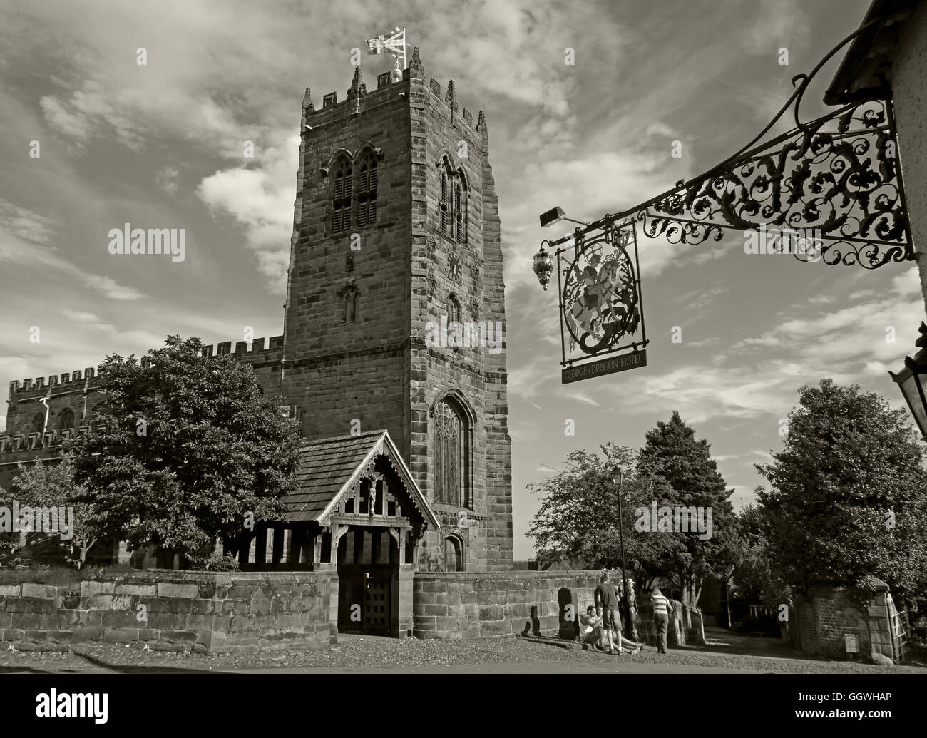 George und der Drache-Schmiedeeisen-Zeichen und St. Marys Church, Great Budworth, Cheshire, England, UK - Monochrom-Sepia Stockfoto