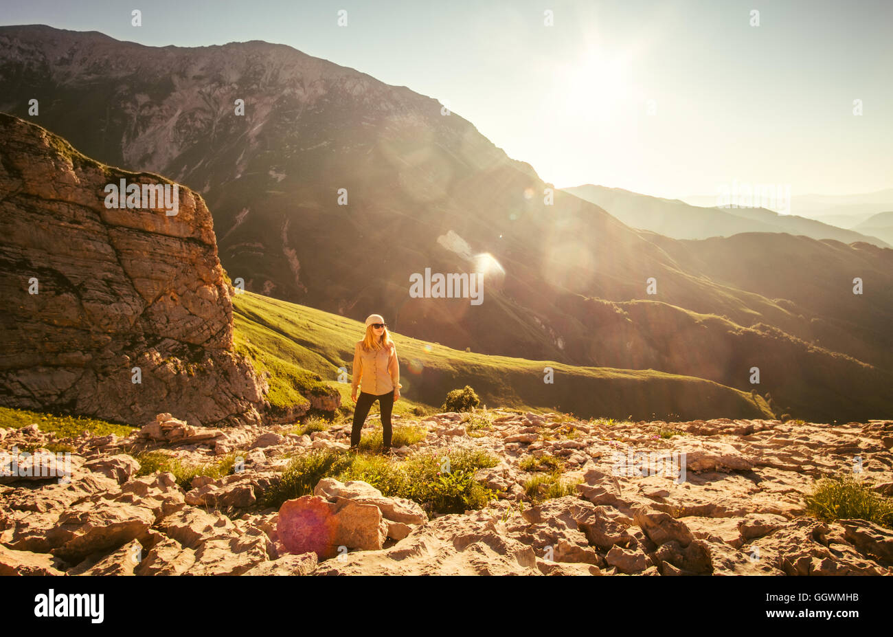 Junge Frau Wandern Outdoor-Reise-Lifestyle-Konzept mit Rocky Mountains und Sonnenaufgang auf Hintergrund Reise Sommerferien Stockfoto