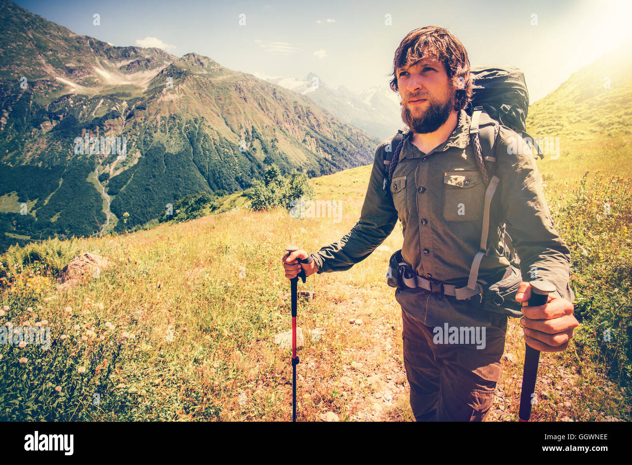 Bärtiger Mann mit Rucksack Reisen Lifestyle Konzept Berge im Hintergrund aktiven Sommerurlaub outdoor Bergsteigen sonnig Stockfoto