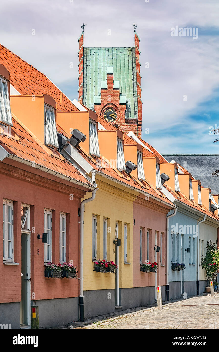 Eine Reihe von Pastelltönen gestrichenen Häuser in Trelleborg, Schweden. Die Kirche im Hintergrund. Stockfoto