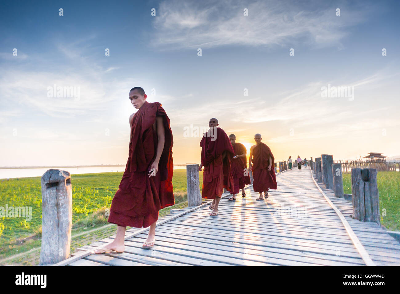 Buddhistische Mönche Sonnenuntergang laufen auf U Bein Brücke Stockfoto